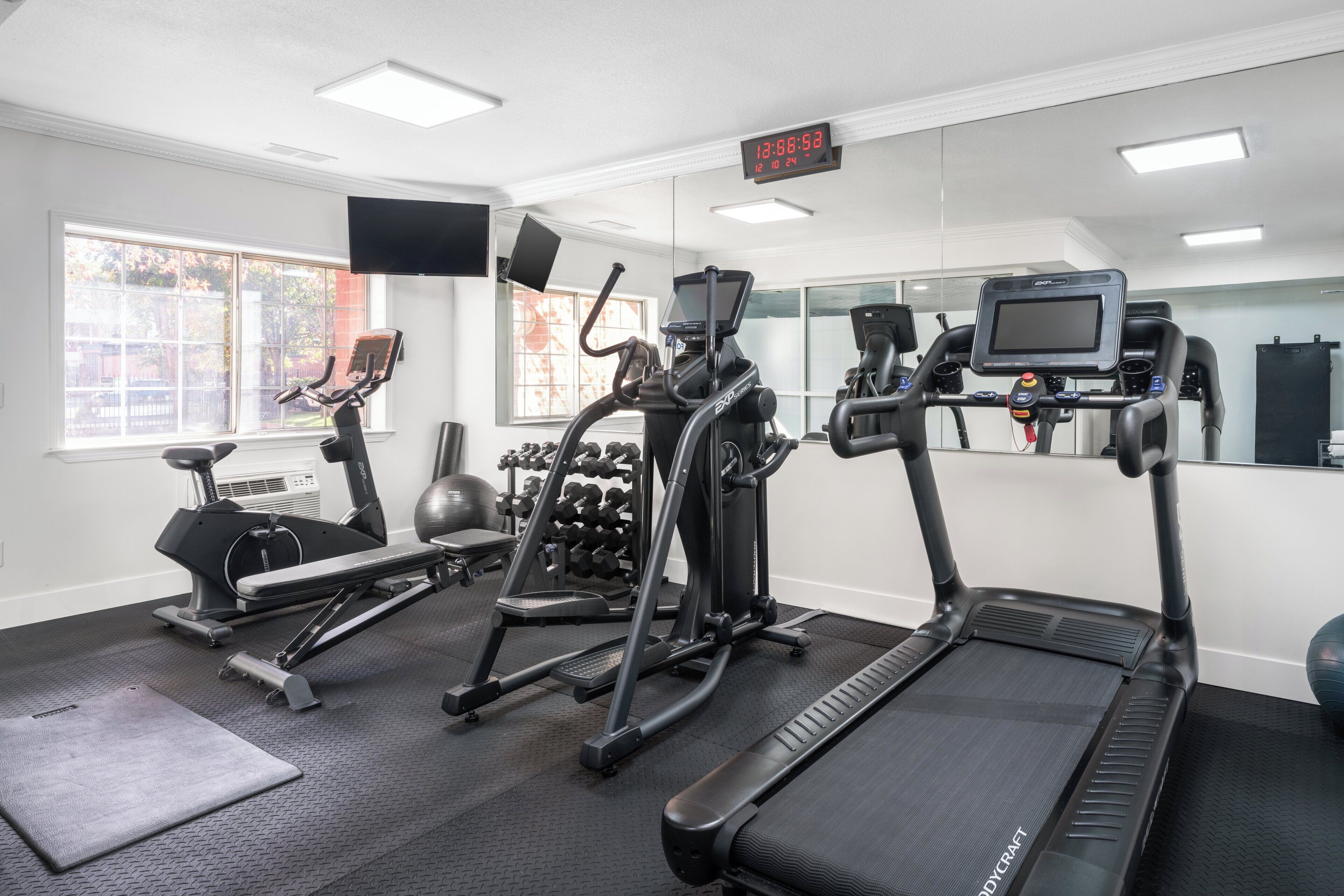 A gym with treadmills, elliptical machines, and weight machines.