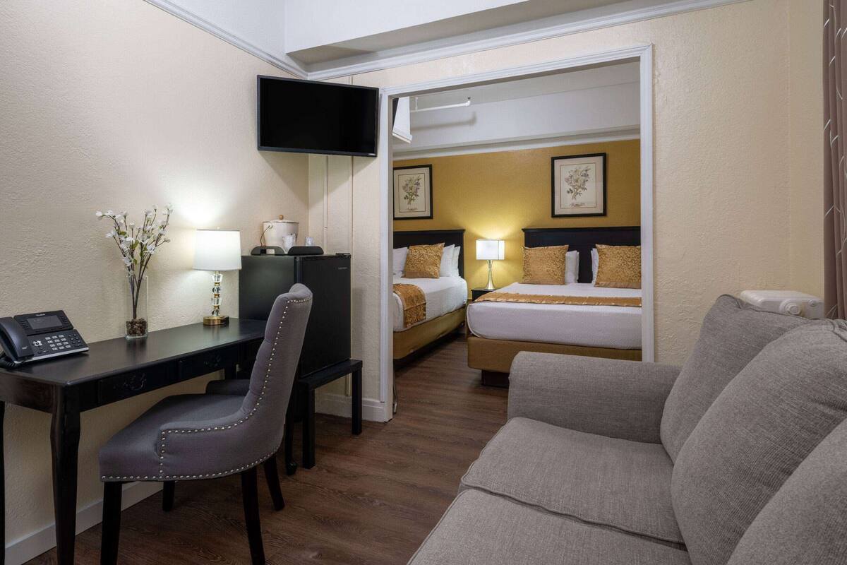 Una habitación de hotel con escritorio, silla, cama y sofá.