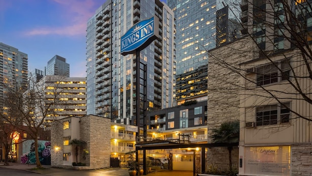 A Kings Inn hotel with a prominent sign, modern architecture, and a well-lit entrance. - The Dylan, a Baymont by Wyndham (Seattle)