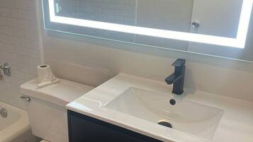 Chambre de base double | Salle de bain | Ensemble baignoire-douche, serviettes fournies, papier de toilette