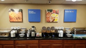 A breakfast buffet setup with various food items and condiments. - Comfort Inn Wethersfield - Hartford (Wethersfield)
