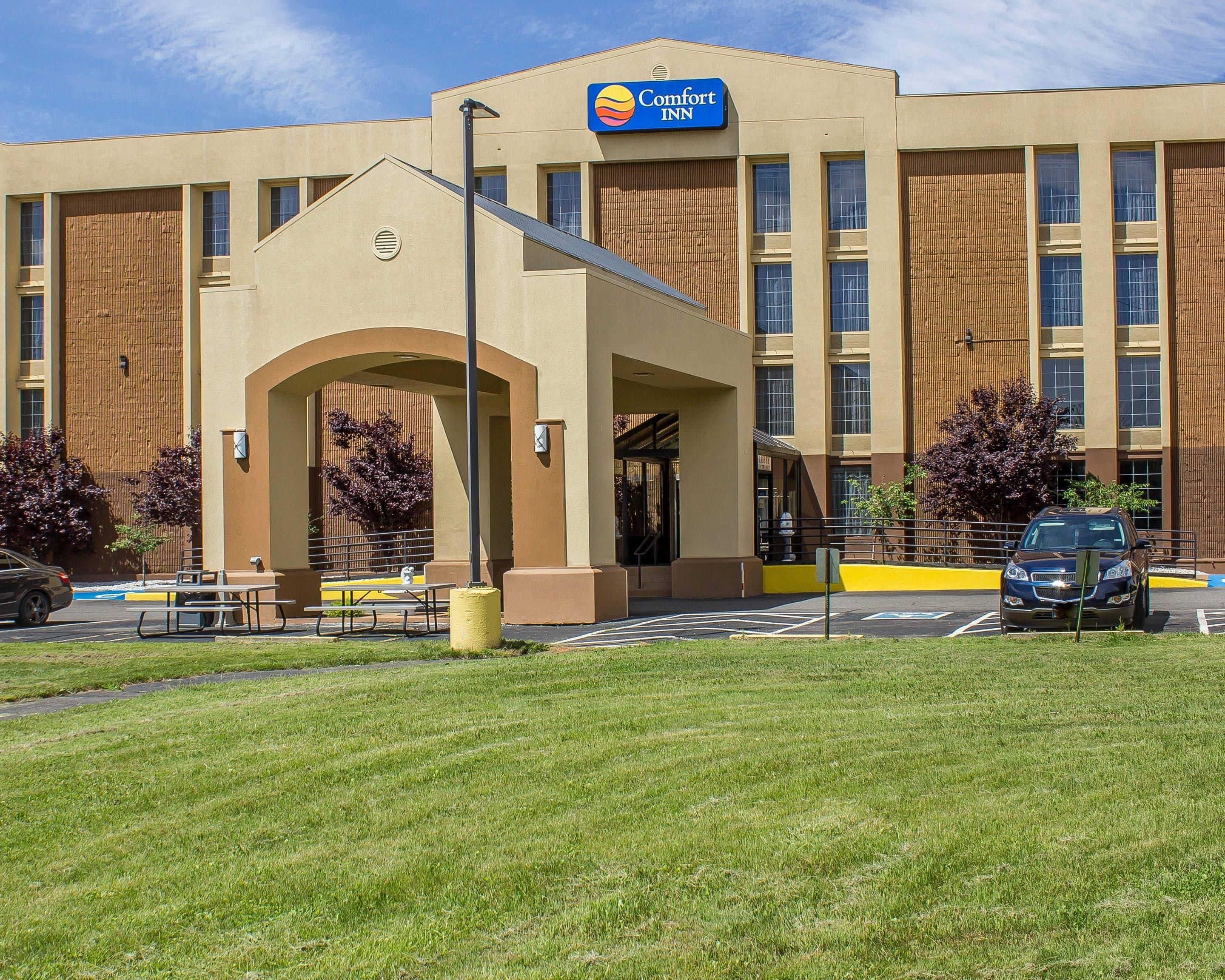 Un hôtel Comfort Inn doté d’une entrée principale, d’un espace extérieur aménagé avec des sièges et d’un parking.