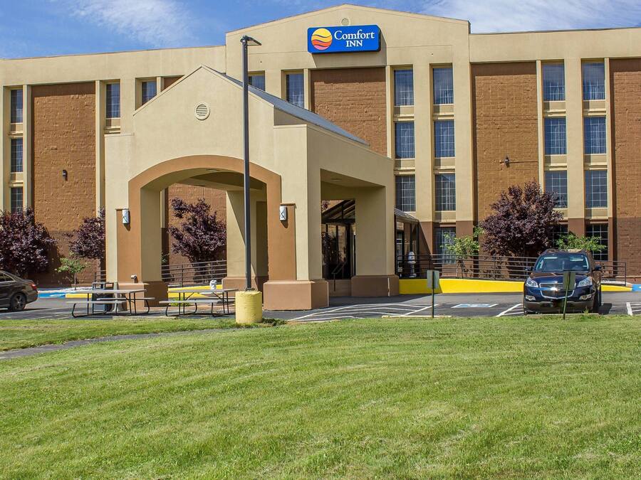 Ein Comfort Inn Hotel mit einem zentralen Eingang, Außenbereich mit Sitzgelegenheiten und einem Parkplatz.