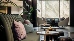 Un vestíbulo moderno con un sofá, sillones y una mesa de centro.