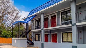 A multi-story building with a blue roof, red doors, and a wheelchair-accessible ramp. - Rodeway Inn & Suites Fort Jackson (Columbia)
