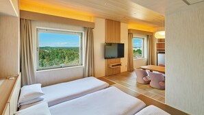 Une chambre d’hôtel avec deux lits, une télévision, un bureau et une vue sur la forêt.