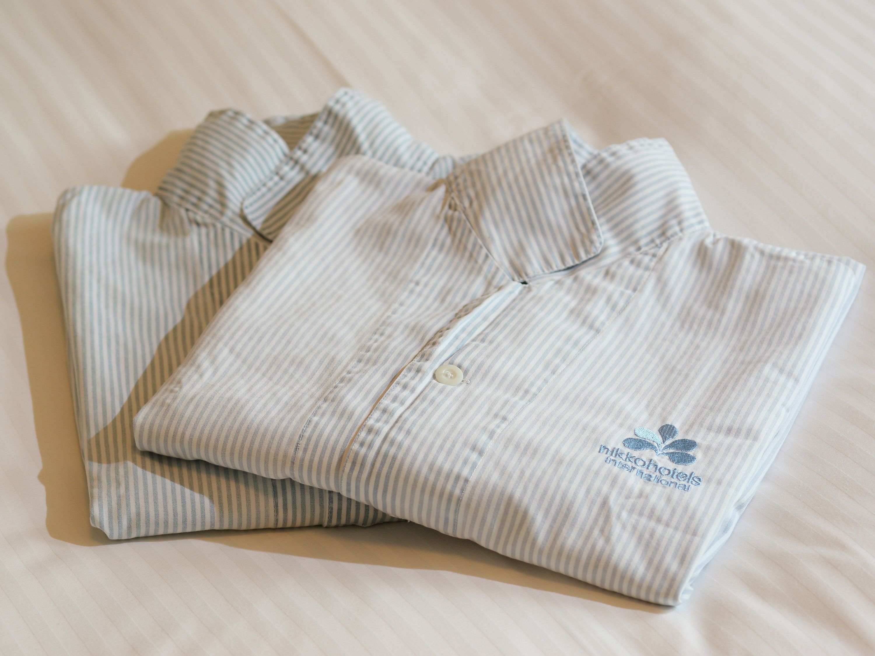 Une chemise rayée, soigneusement pliée, avec un logo sur la poche.