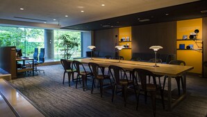 Une salle de conférence avec une longue table, des chaises et une plante.
