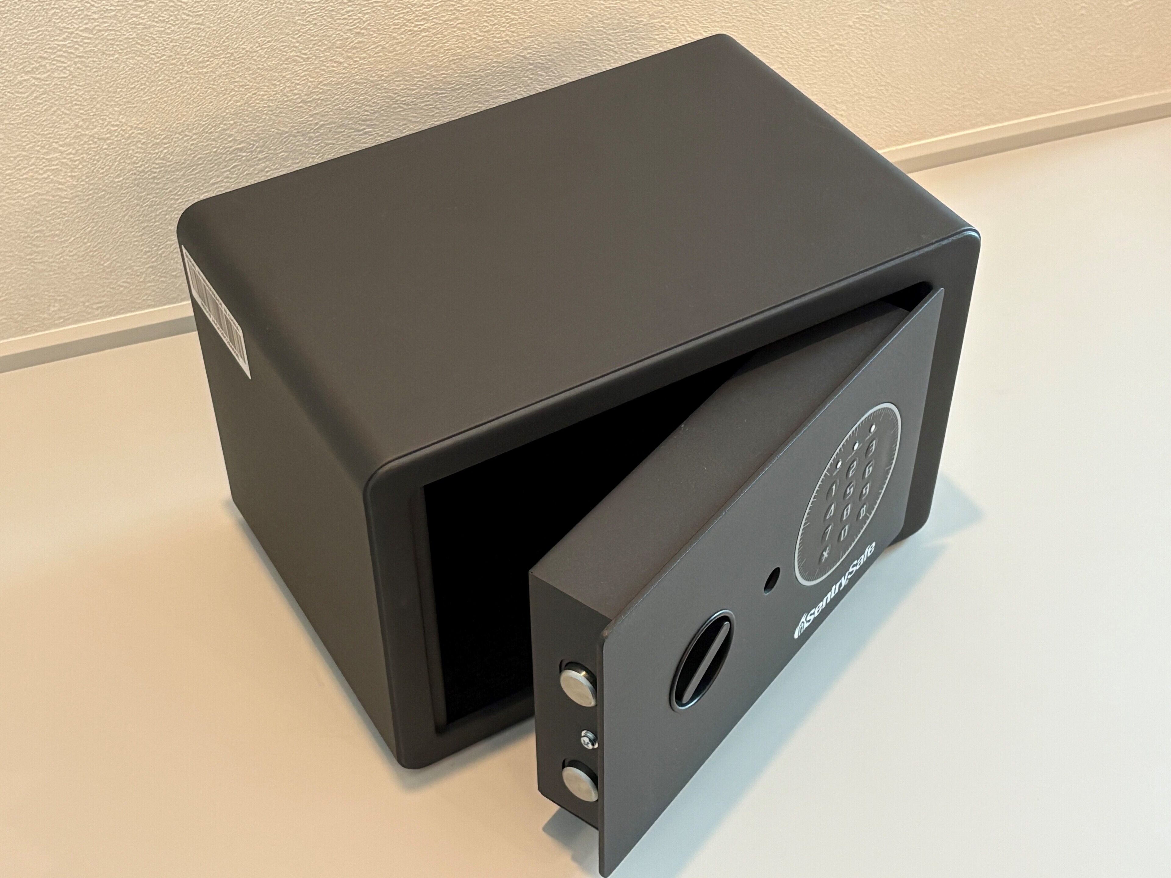 A black, rectangular, metallic object with a circular logo and a small vent on the side.