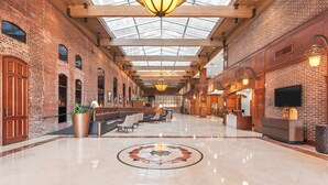 A spacious lobby with a high ceiling, a central fountain, and a reception desk. - Columbus Marriott (Columbus)
