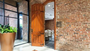 A brick wall with a wooden door leading to a dining area. - Columbus Marriott (Columbus)