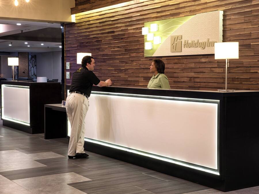 Un mostrador de recepción con un panel de pared de madera y un letrero que dice 'Holiday Inn'.