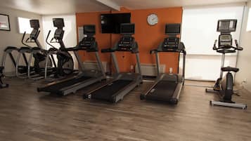 A gym with treadmills, stationary bikes, and exercise equipment.