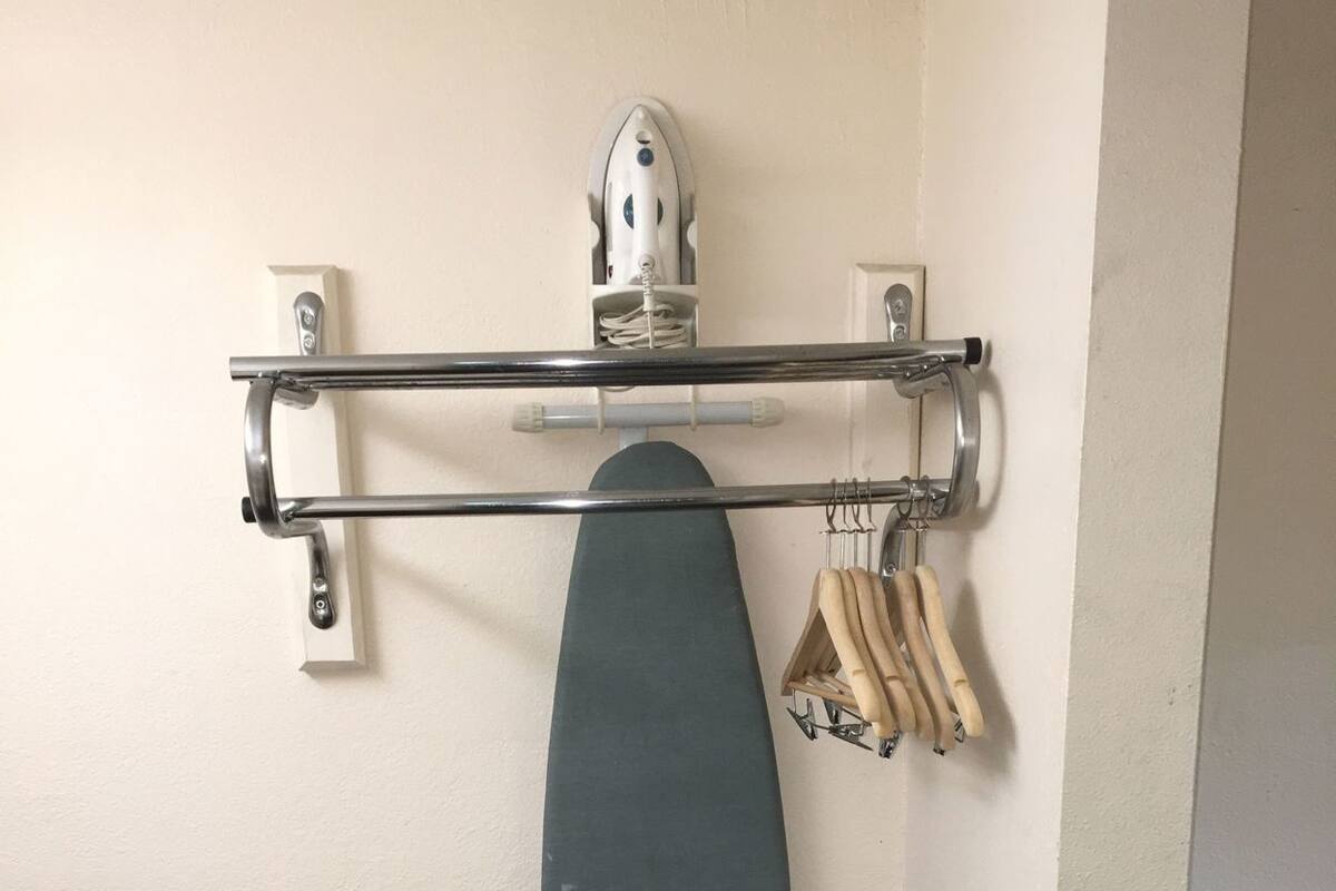 Un estante en la pared con un monopatín, un secador de pelo y un par de tijeras.