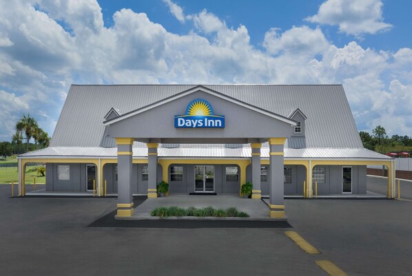 A Days Inn hotel with a flat roof, a central entrance, and a parking lot. - Days Inn by Wyndham Lake City I-75 (Lake City)