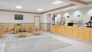 A hotel room with a large bed, a bedside table, a nightstand, a window, and a bathroom with a toilet and sink. - Days Inn by Wyndham Lake City I-75 (Lake City)