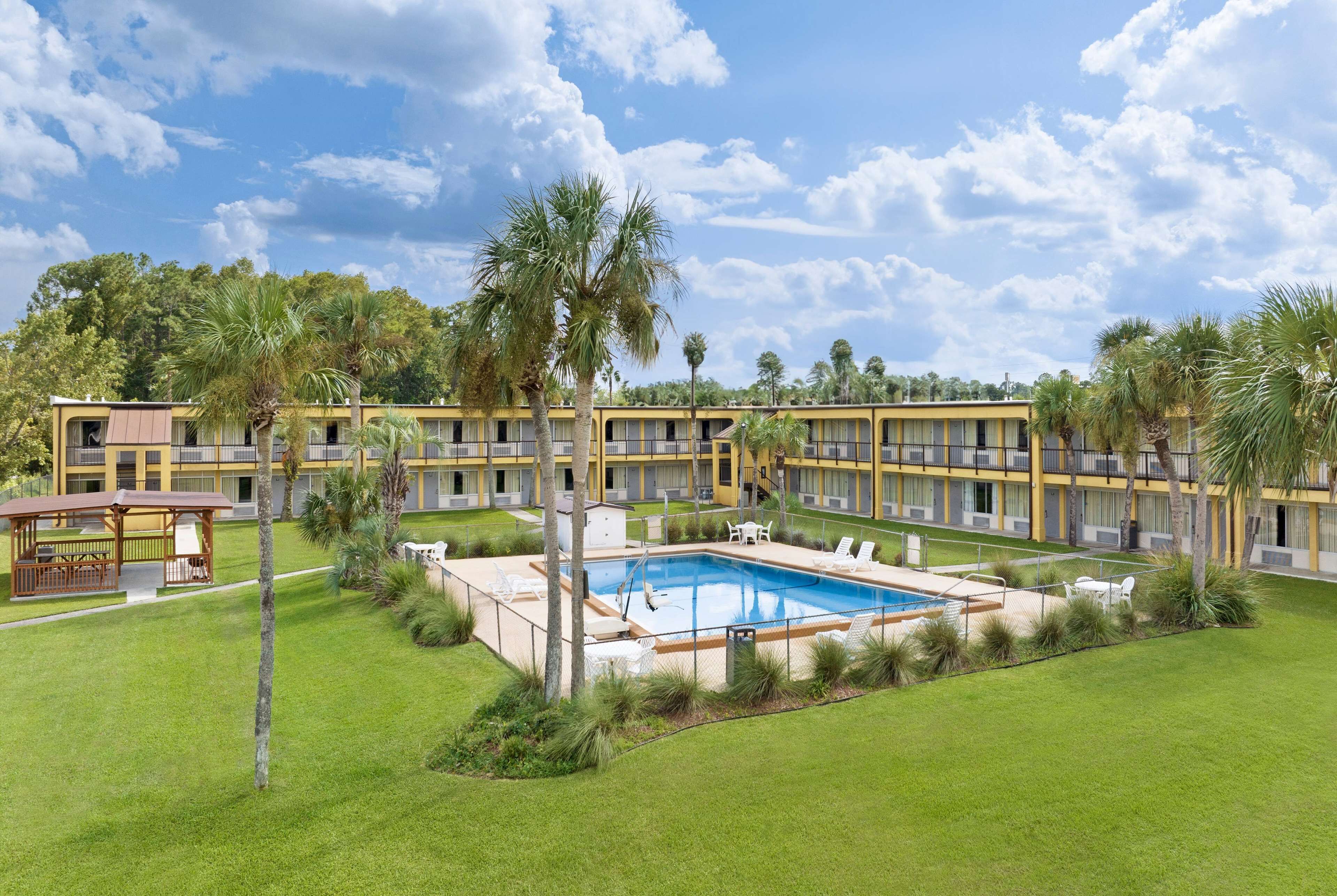 Un hôtel doté d’une piscine, de nombreux balcons et d’une végétation luxuriante.