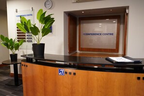 A reception desk with a sign reading 'CONFERENCE CENTRE' and a clock on the wall. - Best Western Heathrow Ariel T2, 3, 4 (Hayes)