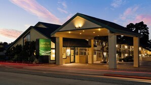 A hotel with a covered entrance, a signboard, and a clear sky. - Scottish Fairway Inn (Monterey)