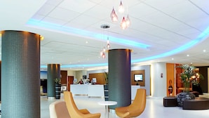 A modern lobby with high ceilings, large columns, and contemporary seating areas. - Novotel London Waterloo (London)