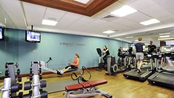 A gym with exercise equipment, a television, and a wall with the text "In Balance by Novotel Fitness".