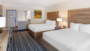 A hotel room with two beds, a desk, a chair, a lamp, and a colorful abstract painting on the wall. - Best Western Posada Royale Hotel & Suites (Simi Valley)