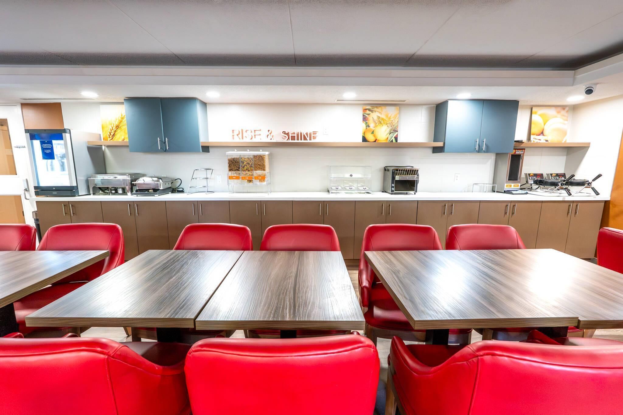 A dining area with red chairs and tables, a kitchen counter with appliances, and a sign reading 'R.I.F. & SHINE'.