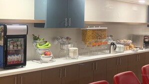 A breakfast bar with a refrigerator, fruit bowl, and coffee station. - Comfort Suites London (London)