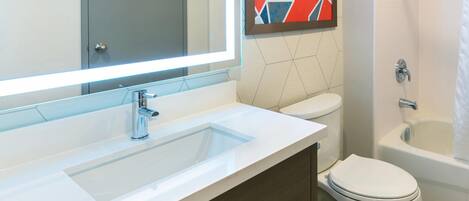 Un baño moderno con un lavamanos rectangular, inodoro y bañera.