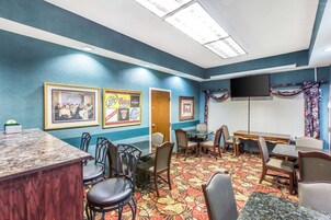 Una habitación de hotel con comedor, bar y televisor.
