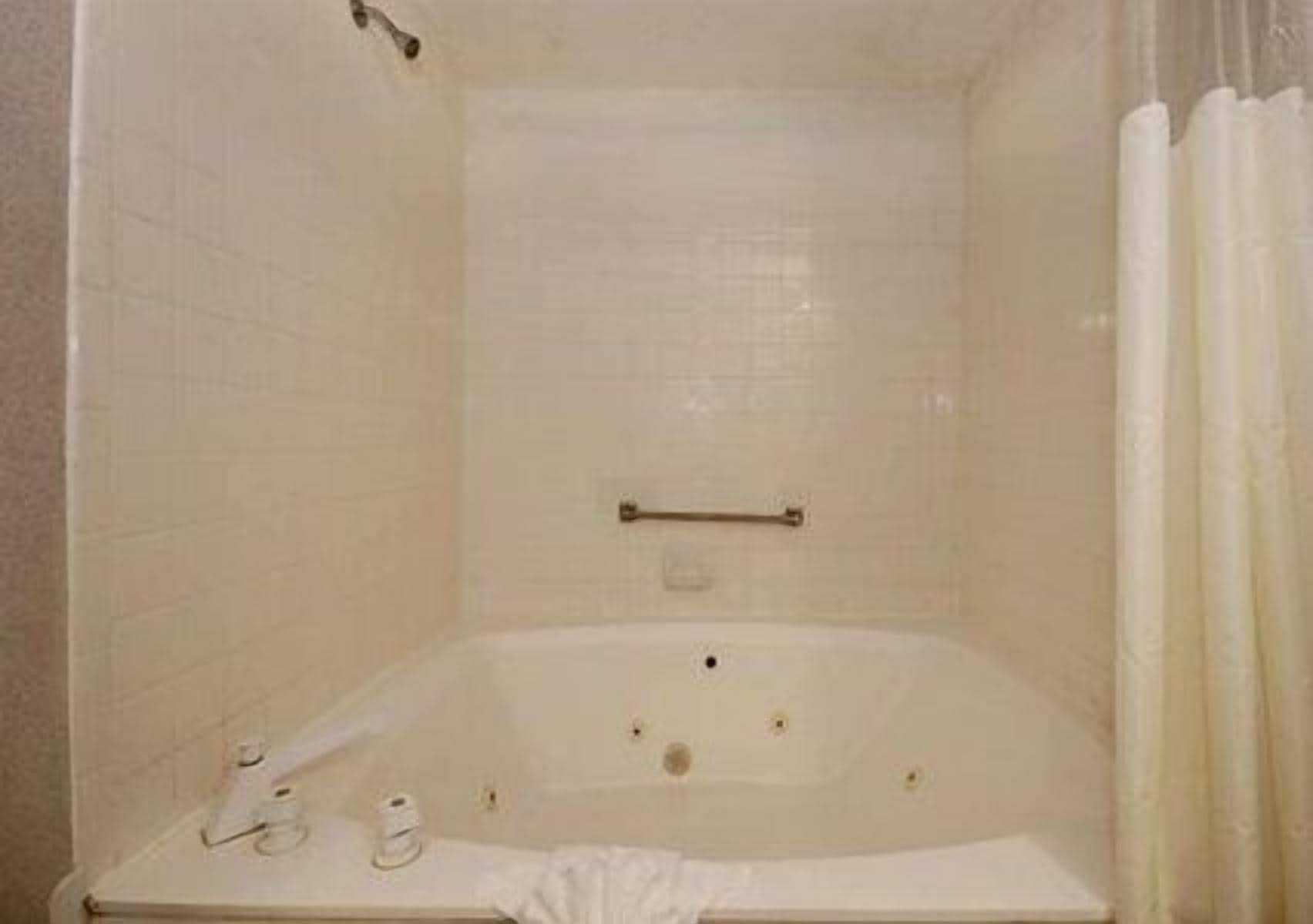Ein Badezimmer mit einer weißen Wanne, einem Handtuchhalter und einer Duschvorhang.