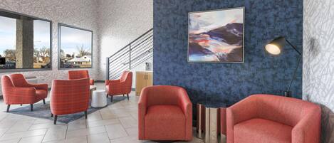 Un vestíbulo moderno con sillones rojos, una escalera y un cuadro abstracto grande.