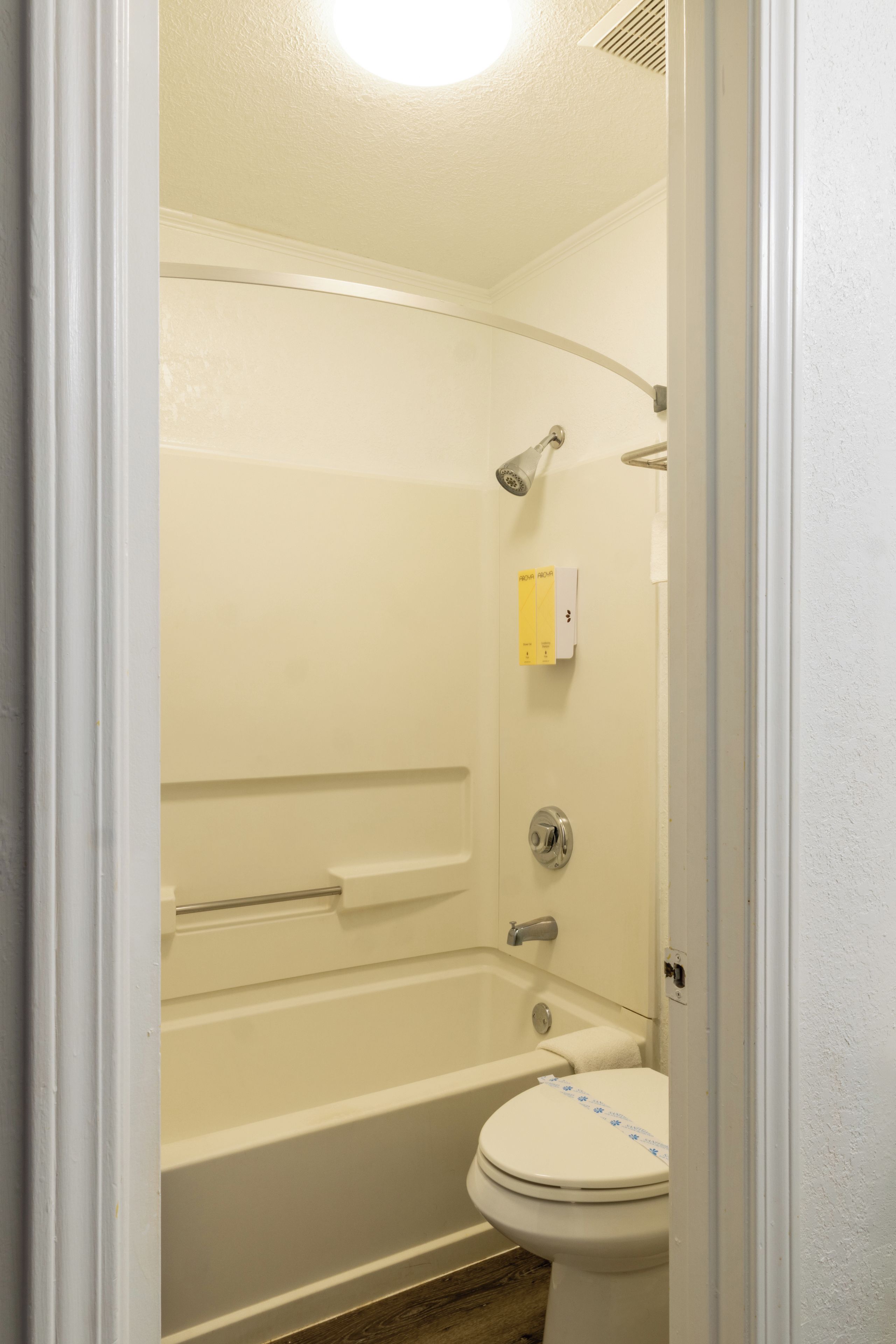 A bathroom with a bathtub, a toilet, and a shower head.