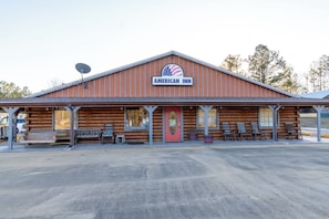 A wooden building with a sign reading 'AMERICAN INN'. - American Inn Motel by Capital O Camden AL (Camden)