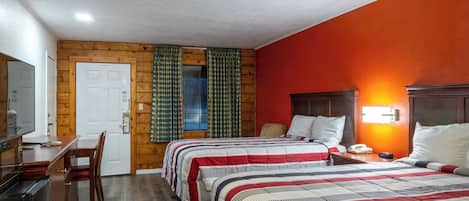 A hotel room with two beds, a desk, and a chair.