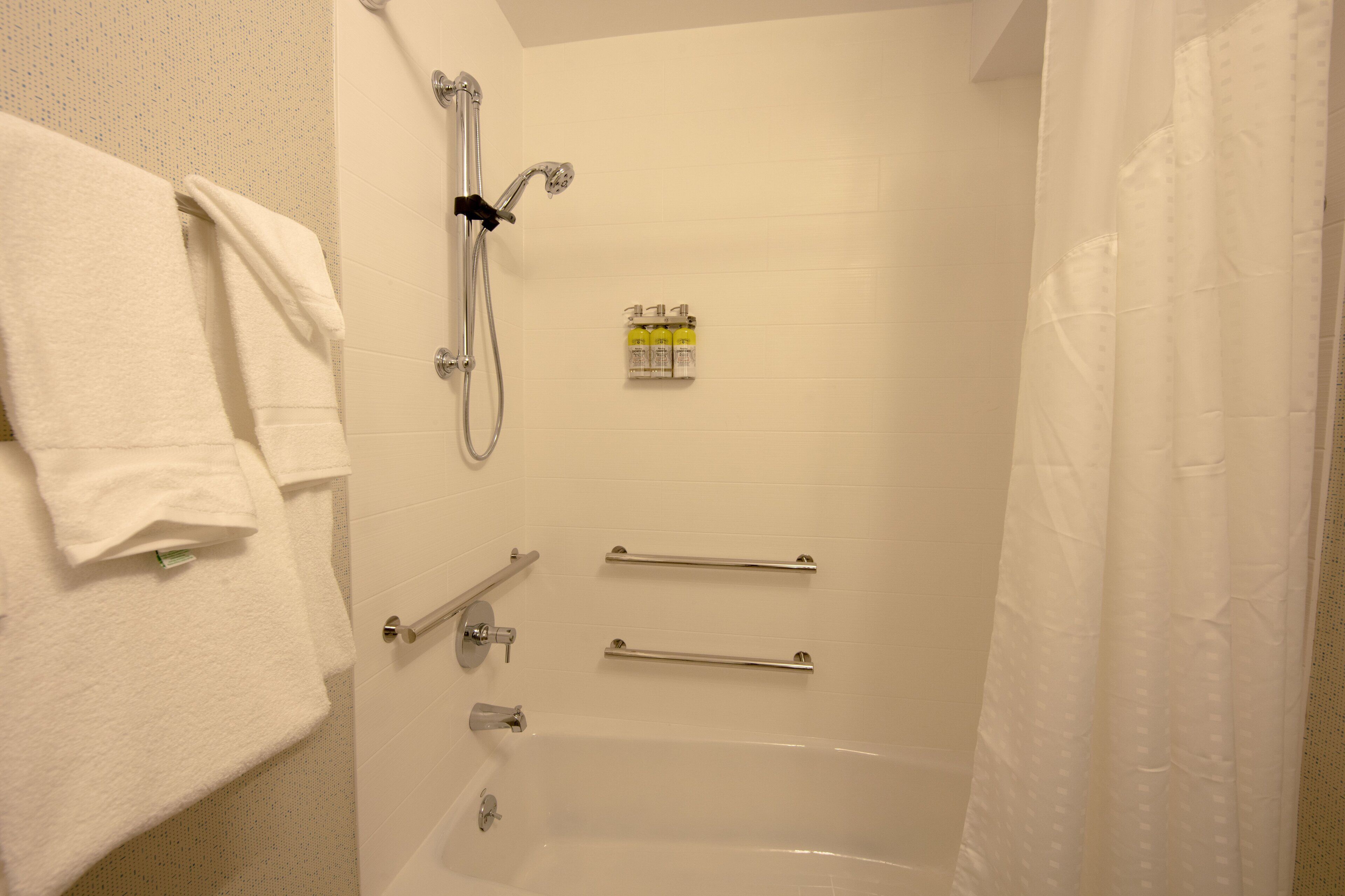 Un baño con bañera, ducha y perchero.