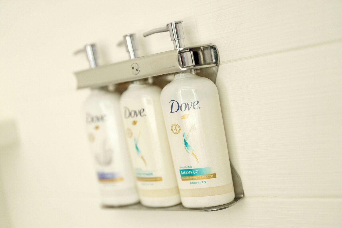 A row of Dove shampoo bottles mounted on a wall.