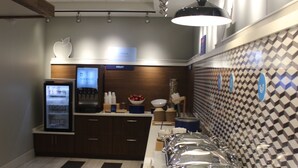 A buffet area with multiple serving stations, a beverage dispenser, and a refrigerator. - Holiday Inn Express Athens by IHG (Athens)