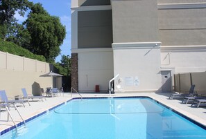 Una piscina al aire libre de temporada, sillones reclinables de piscina