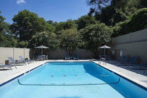 Piscine extérieure en saison, chaises longues