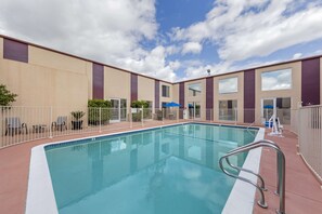 Una piscina al aire libre, sillones reclinables de piscina