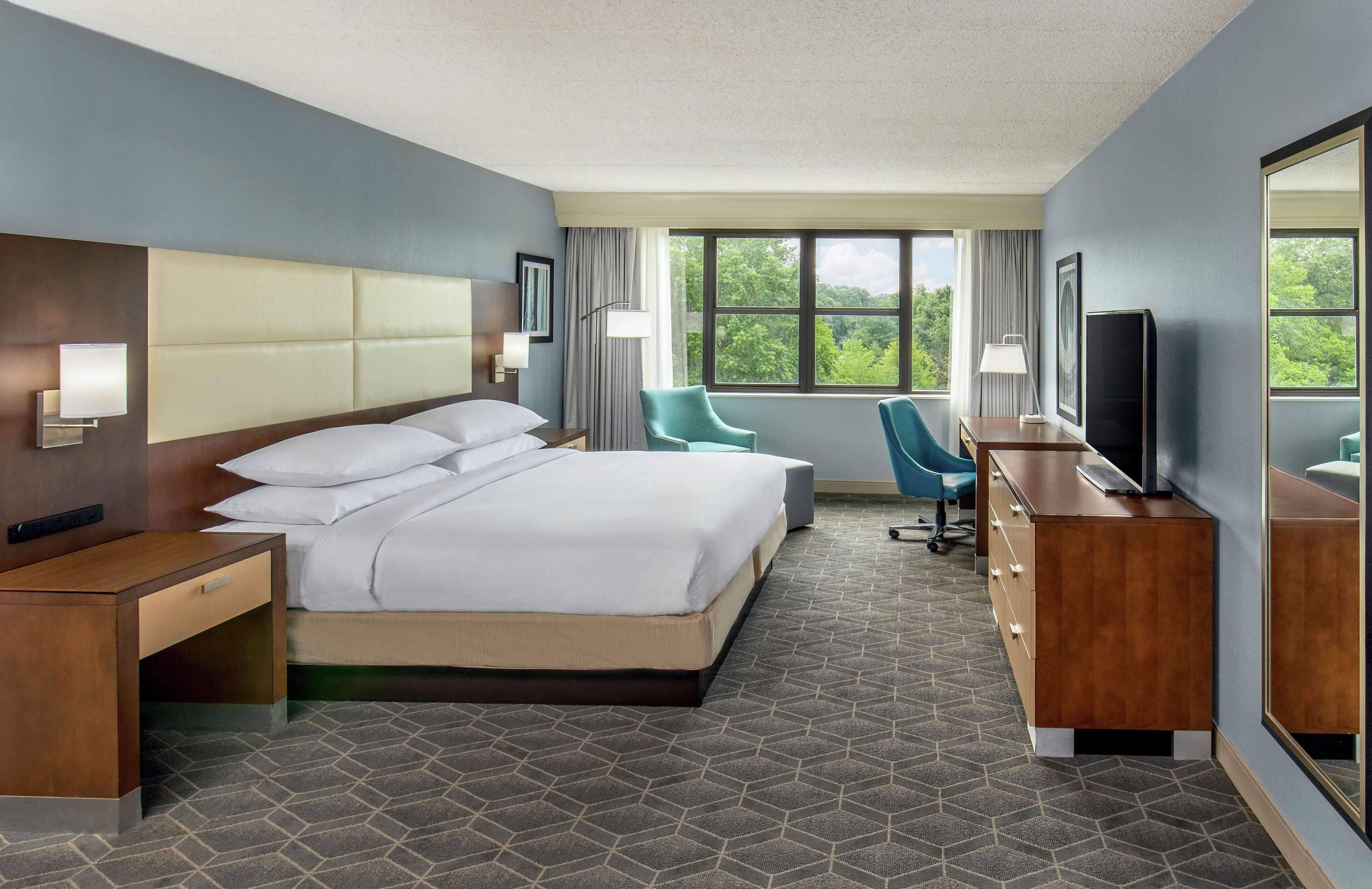 أغطية فراش متميزة وخزنة داخل الغرفة ومكتب ومساحة عمل للكمبيوتر المحمول