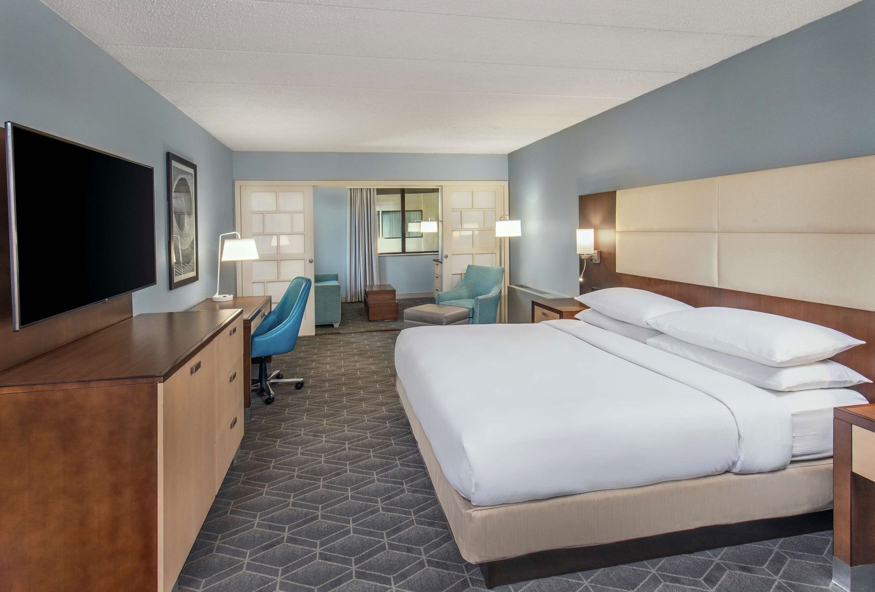 أغطية فراش متميزة وخزنة داخل الغرفة ومكتب ومساحة عمل للكمبيوتر المحمول