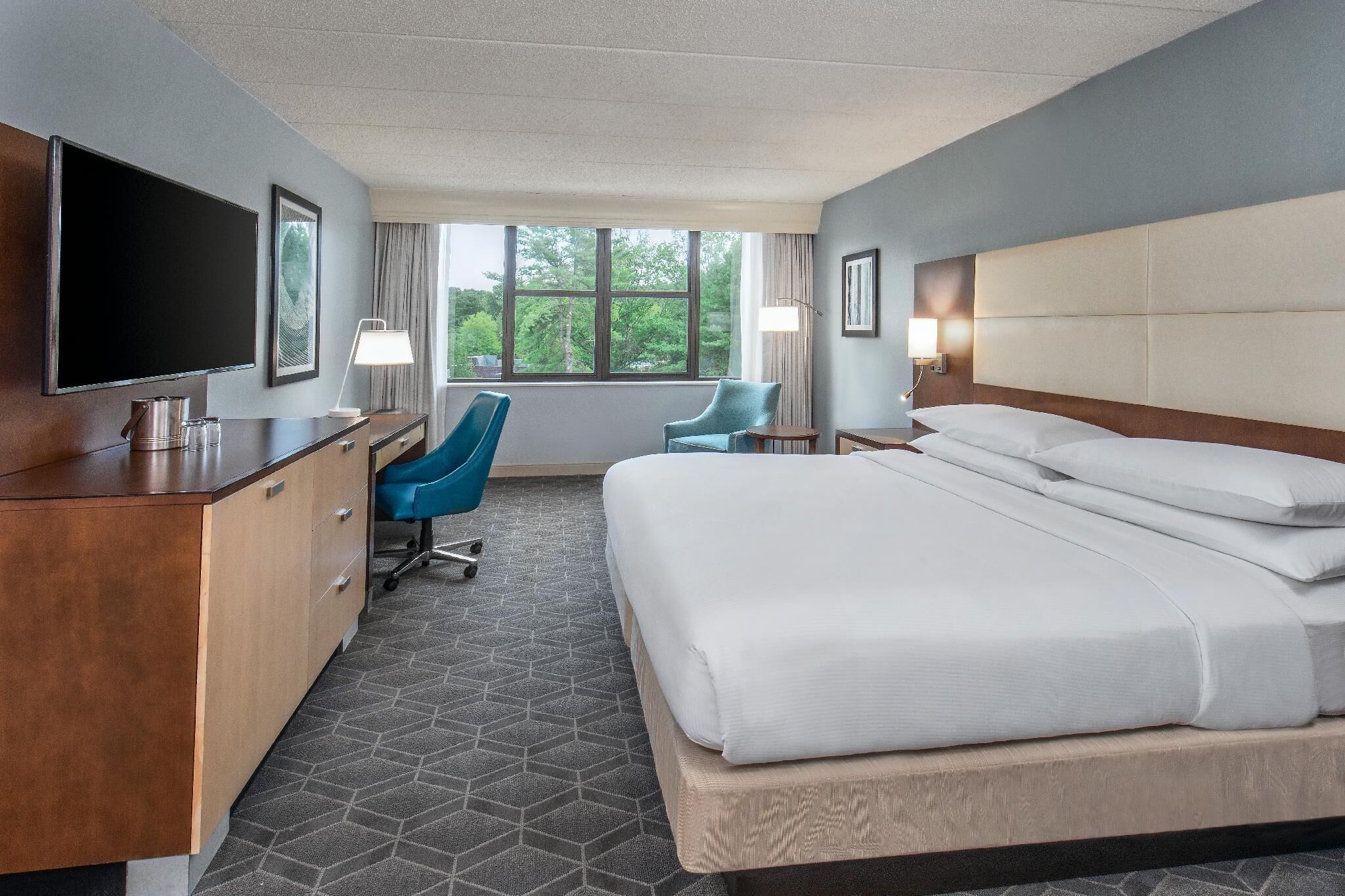 أغطية فراش متميزة وخزنة داخل الغرفة ومكتب ومساحة عمل للكمبيوتر المحمول