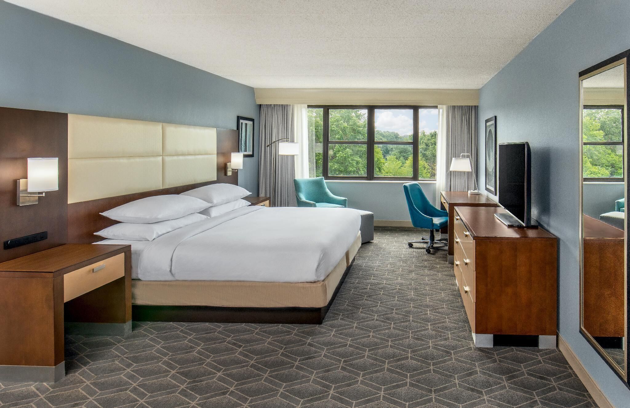 أغطية فراش متميزة وخزنة داخل الغرفة ومكتب ومساحة عمل للكمبيوتر المحمول