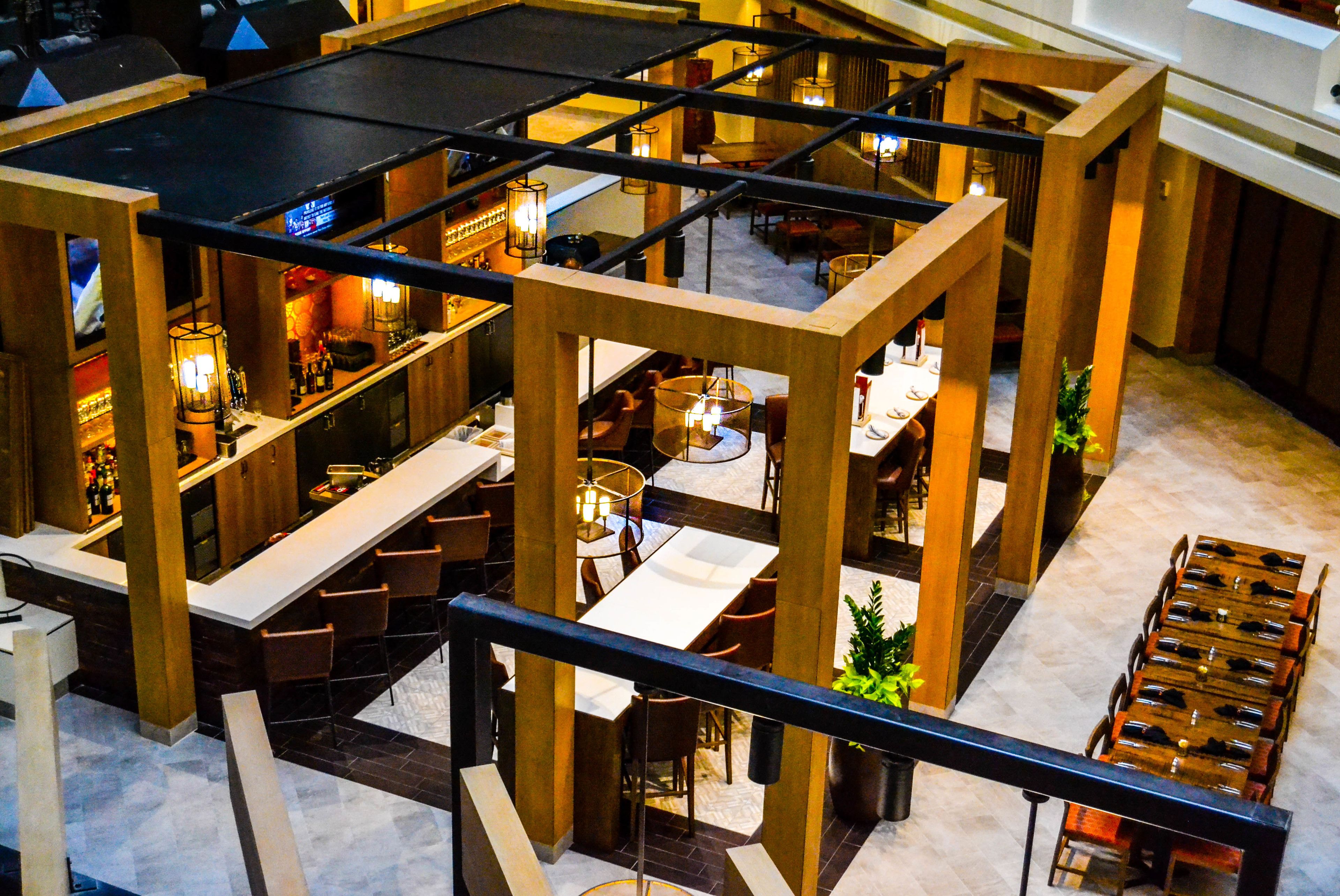 A multi-level restaurant with a bar area, dining tables, and chairs.