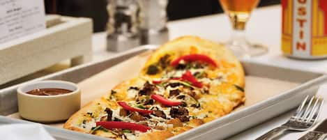 A tray with a pizza, a small bowl of sauce, and a can of Austin beer.