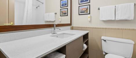 A bathroom with a sink, mirror, toilet, and towel rack.