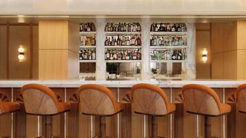 A bar area with multiple stools and a well-stocked liquor shelf.