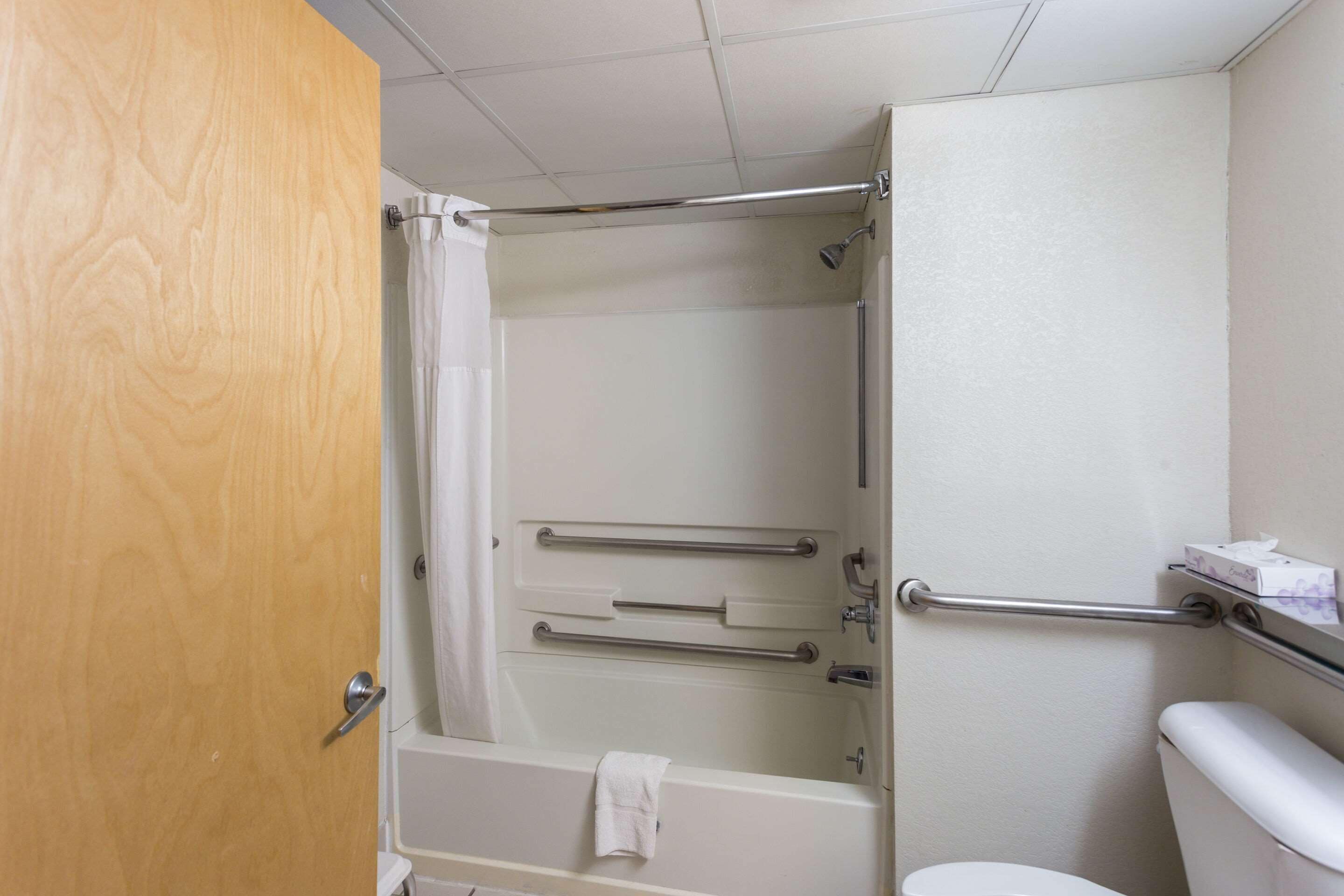 A bathroom with a shower, a toilet, and a bathtub.